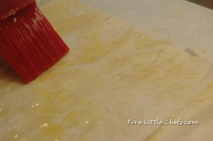 brushing melted butter on filo dough