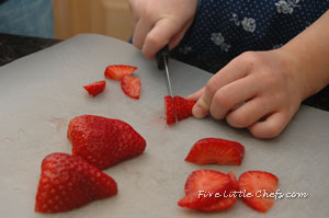 Little Chef D cutting strawberries