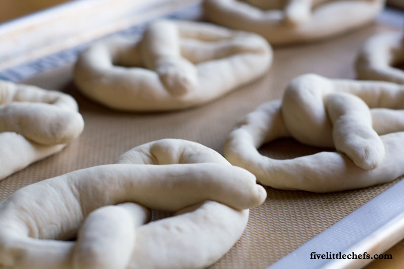 This easy homemade buttery soft pretzels recipe is loved by many! We have made it easy to understand how to make these with step by step instructions.They taste just like the mall but made at home for a great snack. fivelittlechefs.com